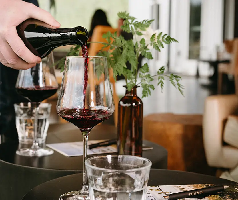 Someone pouring wine.
