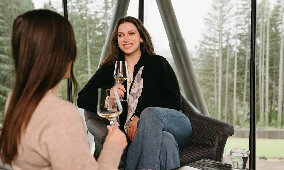 Two friends enjoying wine in the Rex Hill tasting room.