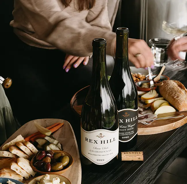 Rex Hill wines on a coffee table beside 2 charcuterie boards.