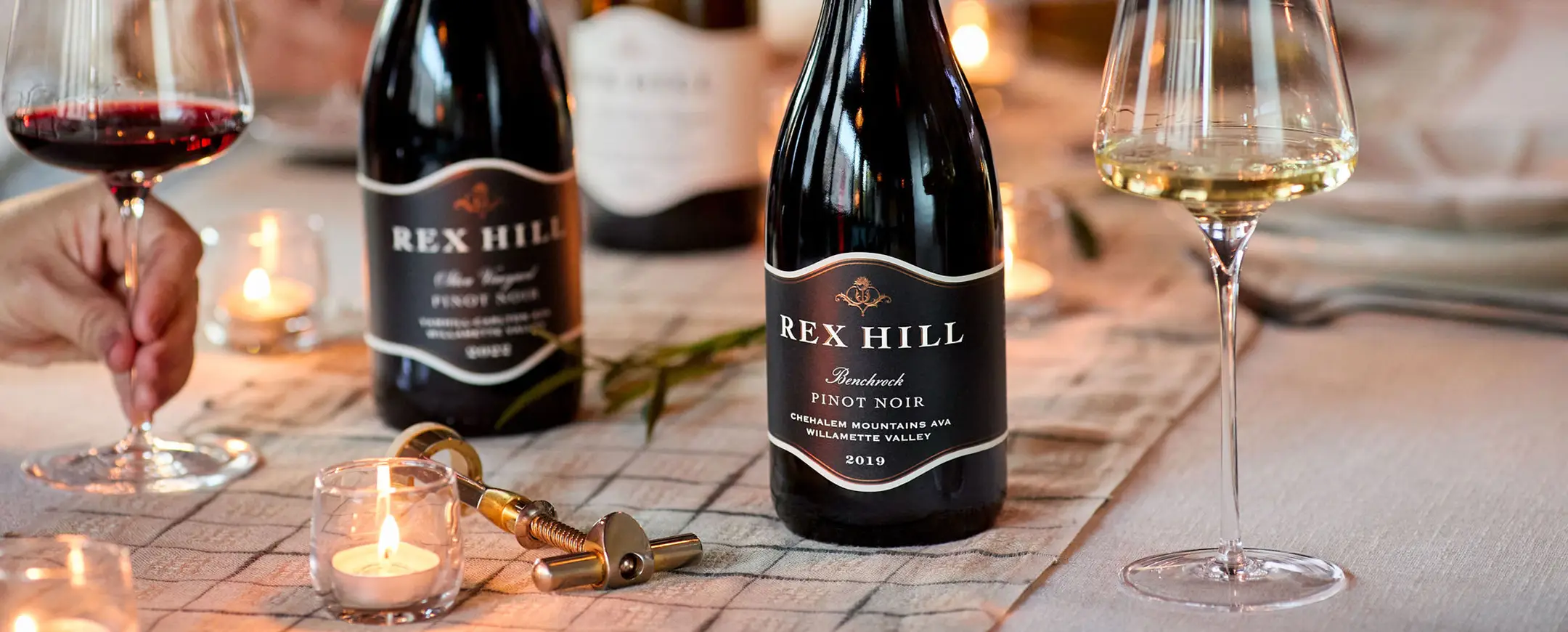 Rex Hill Cellar Club wines on a table with tea lights.