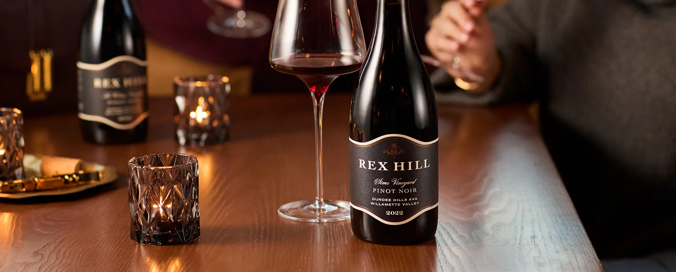 Rex Hill Collectors Club wines on a table with tea lights.