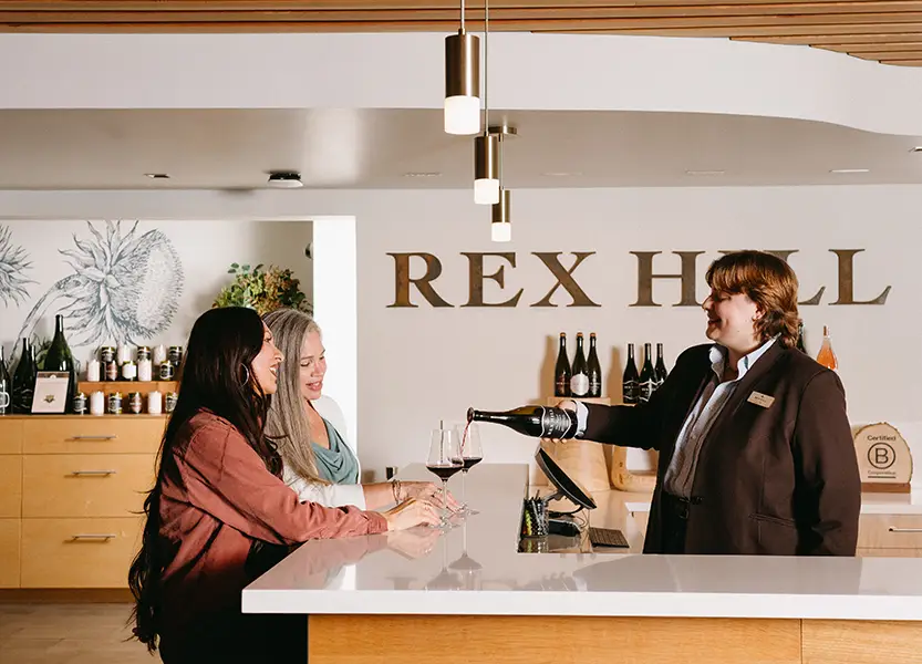 Rex Hill staff member serving two ladies.