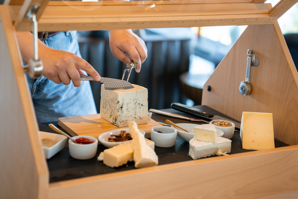 A REX HILL employee prepares cheese to be served.